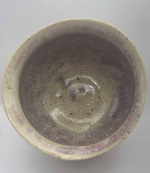 Top view inside handmade ceramic planter showing variegated glaze and drainage holes