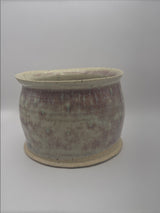 Small handmade ceramic planter with variegated glaze on white background