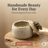 Ceramic container with lid on a wooden surface, with text 'Handmade Beauty for Every Day' and 'Artisanal elegance for your home.'.